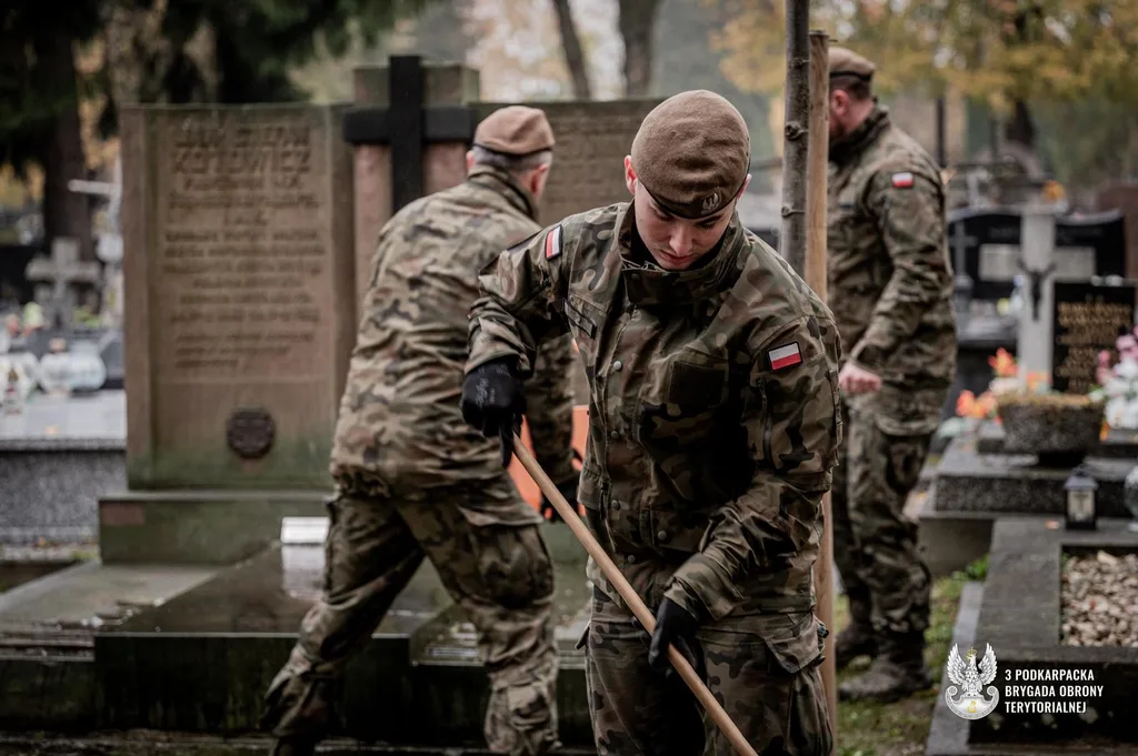 Żołnierze WOT czyszczągroby na cmentarzu przed dniem Wszystkich Świętych